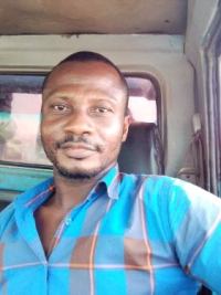 cyprian wearing a blue shirt sitting in vehicle